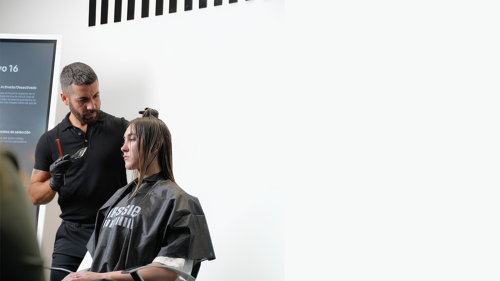 Un técnico de la marca trabaja el color sobre una modelo en el salón-escuela.